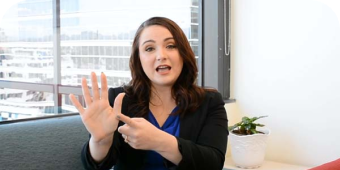 Woman sitting in an office with her palm up and counting. 